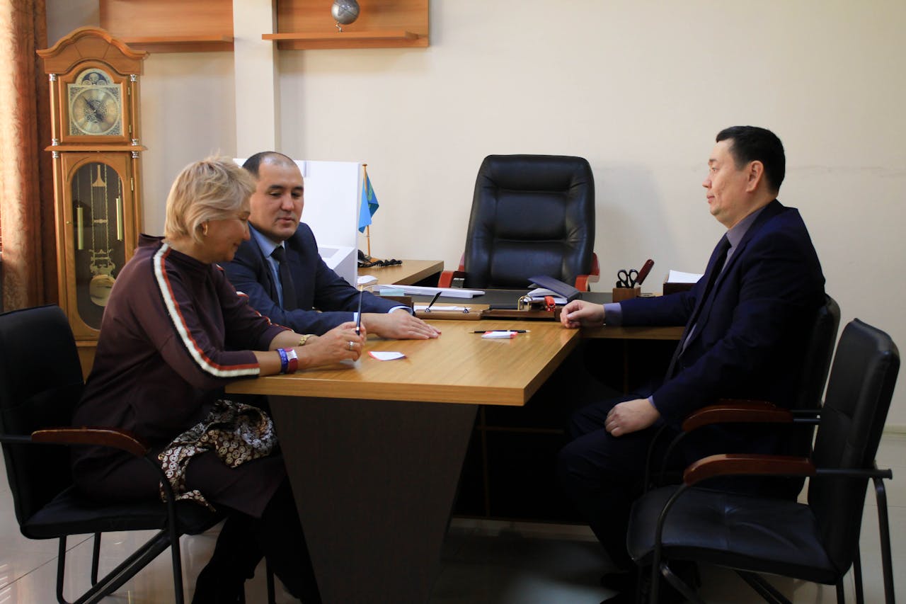 stats-img Executives discussing strategy around a conference table in a formal office environment.